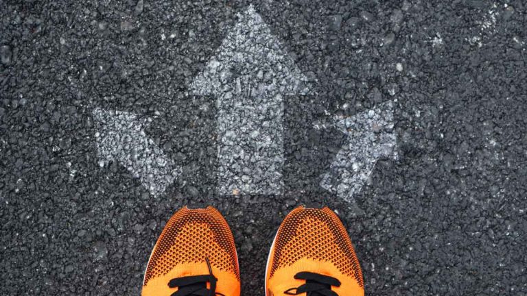 Running shoes next to arrows